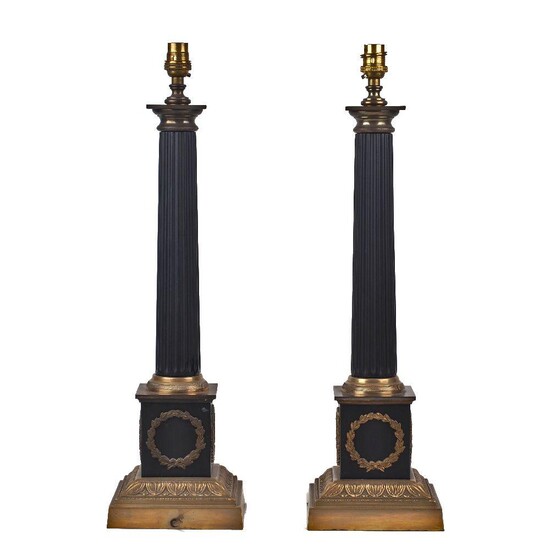 Two gilt and patinated metal Regency style lamps, late 20th century, each of column form with wreath mounts to the bases, 49cm high (2) It is the buyer's responsibility to ensure that electrical items are professionally rewired for use.