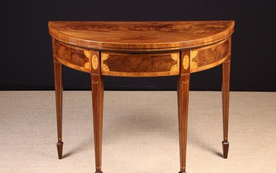 A 19th Century Inlaid Mahogany Demi-lune Card Table. The flame figured top with cross-banded border