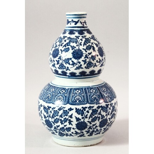 A CHINESE BLUE AND WHITE DOUBLE GOURD VASE, painted with lot...