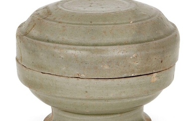 A Chinese grey stoneware celadon footed box and cover, Ming dynasty, incised to the cover with three circular bands raised on spreading circular foot, 8.5cm diameter