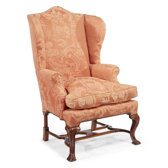 A George II style mahogany wingback chair upholstered in...