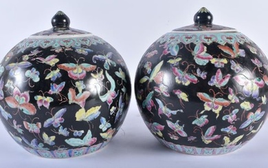 A PAIR OF CHINESE FAMILLE NOIRE PORCELAIN GINGER JARS AND COVERS painted with butterflies and vines.