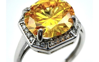 A sterling silver ring with a large round cut yellow moissan...