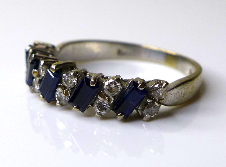 An 18ct white gold, dark sapphire and diamond ring, five bag...