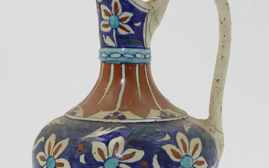 An Iznik-style pottery ewer, Qajar Iran, 19th century, with looping handle, the...