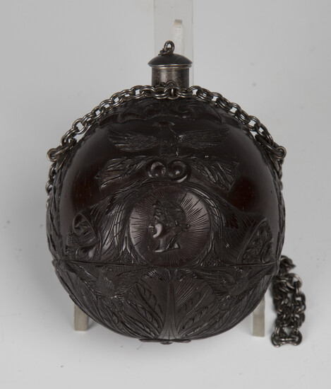An early 19th century finely carved coconut bugbear powder flask of Napoleonic interest, one end typ