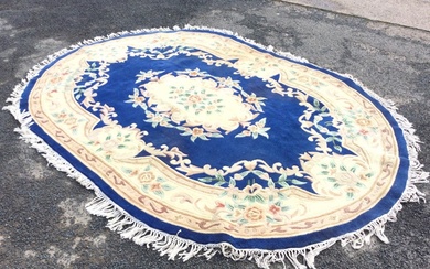 An oval Chinese aubusson style rug with central floral medallion...