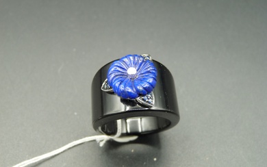 Bague en onyx sculpté, la partie centrale agrémentée d'une fleur en lapis lazuli centrée d'un...