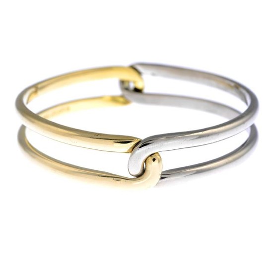 CARTIER - an 18ct gold bangle. Designed as two