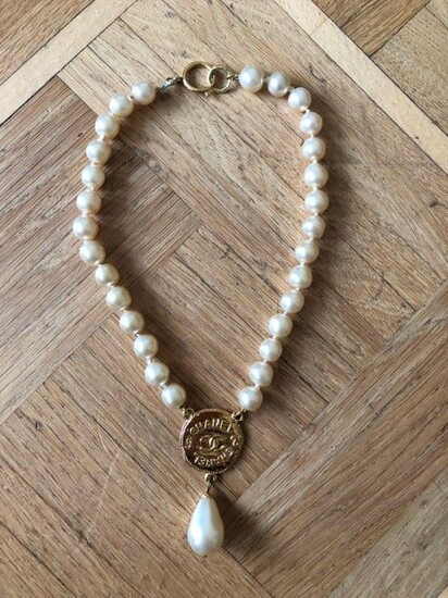 CHANEL. Rare collier de perle baroque gold fini par un pendentif rond doré et d'une perle en goutte. Siglé au dos. Circa 1994. Très bel état.