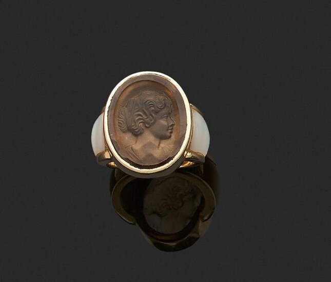 RING in yellow gold 750 thousandths, decorated with an engraved stone showing a woman in profile bust, between two mother-of-pearl motifs. Finger size : 52. Gross weight: 14.4 g. (traces of glue). Yellow gold ring decorated with an engraved stone...