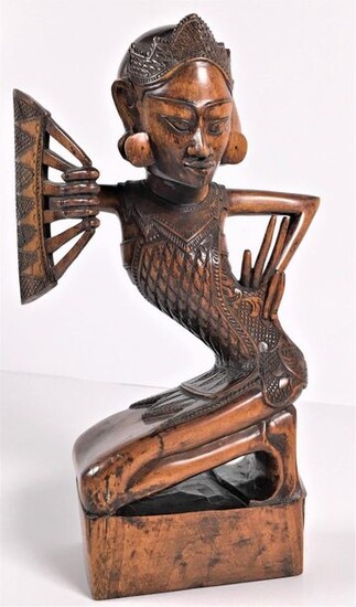 [Sculptures]. A legong dancer with fan, Bali. Carved...