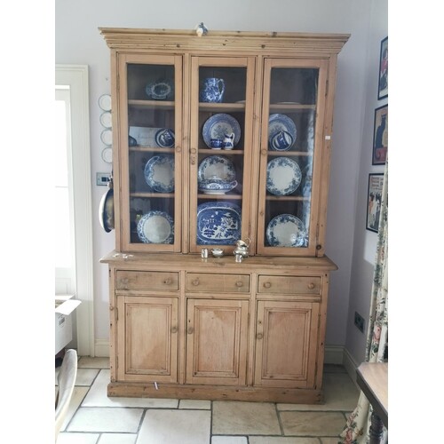 Stripped pine kitchen cabinet the three glazed doors over th...
