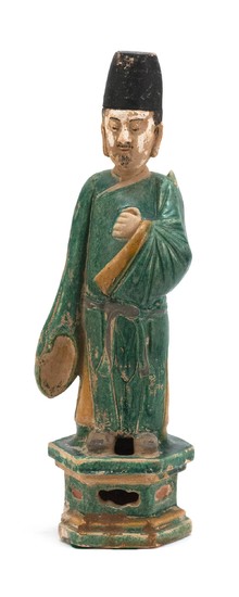 TWO CHINESE POTTERY FIGURES 1) In the form of an attendant wearing green and yellow robes standing on a hexagonal platform. Height 1...