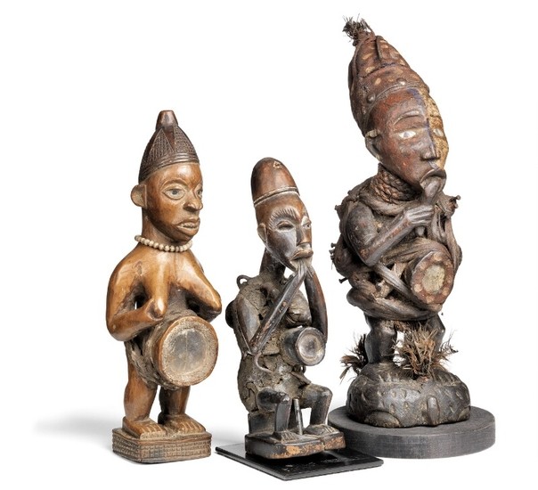 Three fetish figures of carved patinated wood clad with beads, mirrored glass and textiles. Yombe and Vili style. H. 26–37 cm. (3)