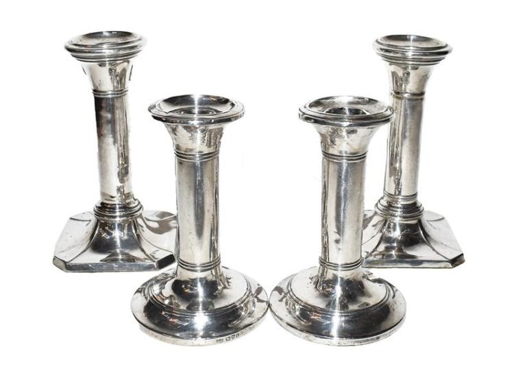 Two pairs of silver candlesticks, filled (4)