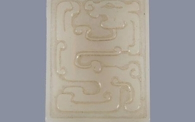 A Chinese white jade buckle, carved with archaic