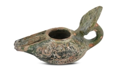 AN EARLY GREEN-GLAZED POTTERY OIL LAMP Possibly Syria,...