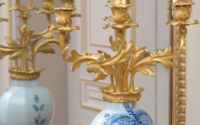 Paire de vases Delft XVIIIe s. en faïence bleu blanc, monture de style rocaille XIXe s., en bronze ciselé et doré formant flambeaux