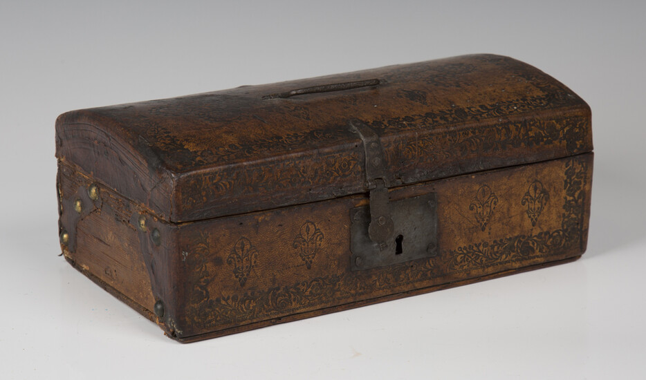 A 19th century Tudor Revival tooled leather domed-top box with handcrafted ironwork and paper-lined