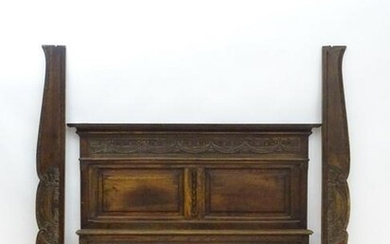 A 19thC carved oak bed with a moulded cornice and