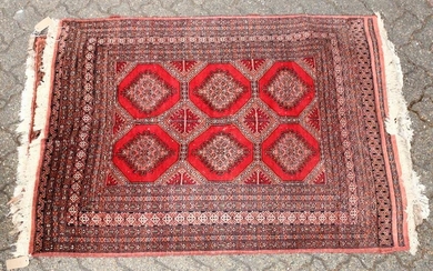 A 20TH CENTURY BOKHARA STYLE RUG, red ground with six
