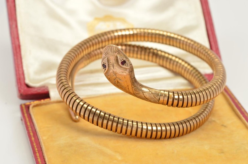 A COILED SNAKE BANGLE, of sprung design in a double coil, wi...