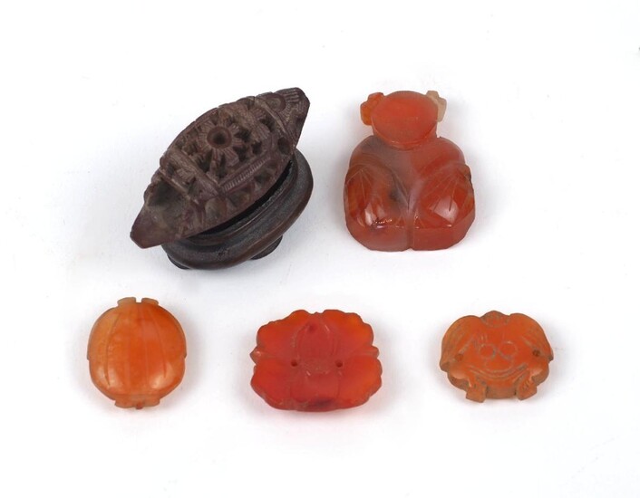 A Chinese hediao nut and stand, early 20th century, carved as a boat, 4.5cm long, and four small hardstone carvings (5)