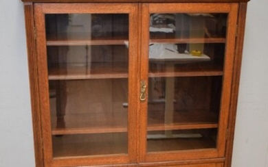 A GILLOW OAK BOOKCASE WITH GLASS FRONT (150H x 107W x 35D CM) (PLEASE NOTE THIS HEAVY ITEM MUST BE REMOVED BY CARRIERS AT THE CUSTOM...