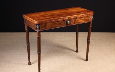 A George IV Fold Over Mahogany Card Table inlaid with ebony bands and mounted with carved lion masks