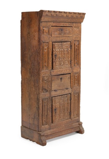 A Gothic oak cabinet, richly carved with folding work and foliage, front with two doors, leaf and drawer. 15th-16th century. H. 169. W. 75. D. 46 cm.