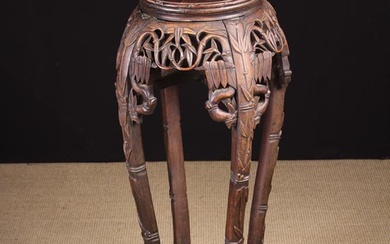 A Late 19th/Early 20th Century Chinese Carved Hardwood Jardiniere Stand. The round top inset with pi