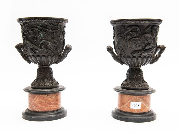 A PAIR OF FRENCH BRONZE URNS WITH DEEP CAST DECORATION ON MARBLE BASES (A/F CHIPS TO MARBLE)