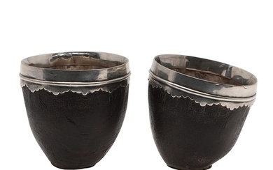 A PAIR OF SILVER MOUNTED COCONUT CUPS. with cut rims and eac...