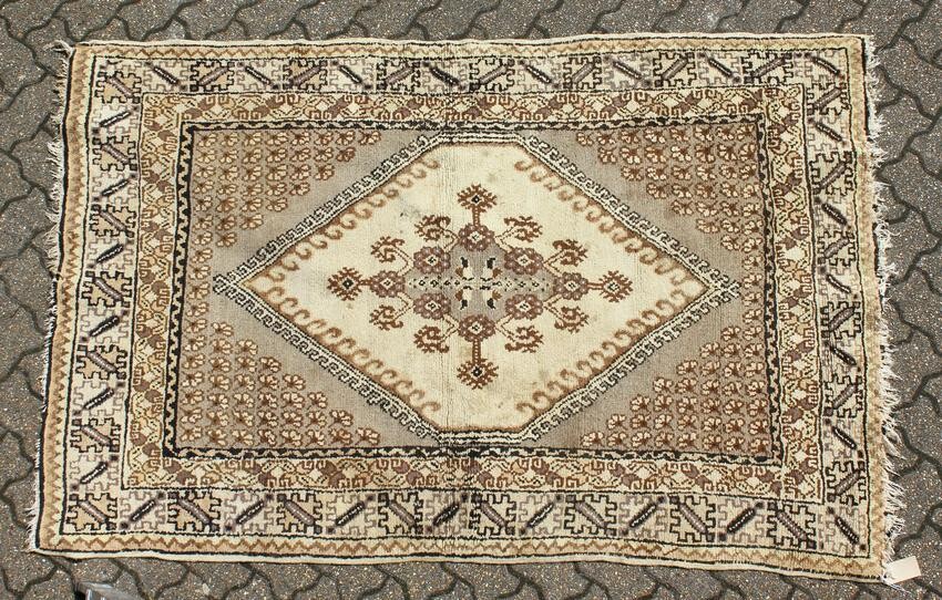 A PERSIAN RUG brown and cream with large medallions.