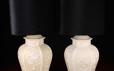 A Pair of Large Ceramic Side Lamps. The hexagonal baluster bodies relief-moulded with sprays of flow