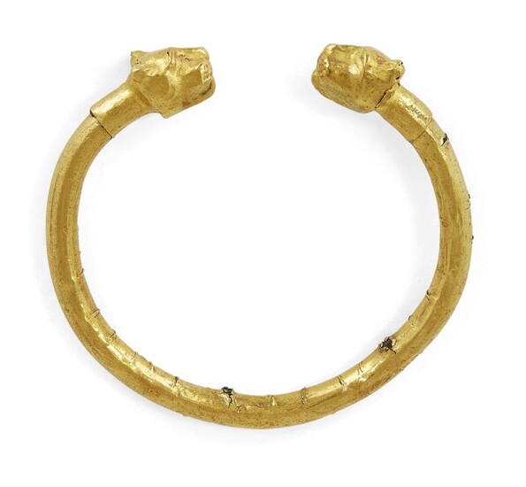 A Parthian gold sheet bracelet with lion head terminals,1st century AD, the gold wrapped penannular bracelet with lion-head terminals, the lions with fierce expression, exposed canines and ears pulled back, ribbed collar behind the neck, 7.5cm...