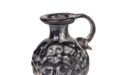 A Roman deep aubergine glass head jug