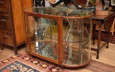 A TIMBER AND GLASS OVAL DISPLAY CASE WITH BRASS DETAILS (H 81 X W 121 X D 61 CM)