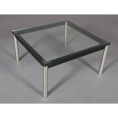A clear glass coffee table, square, on black and chrome tubu...