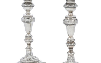 A pair of Brazilian candlesticks, Rio de Janeiro, 19th century, bases stamped 10 and FSB for Francisco de Souza Barbosa, the knopped stems engraved with floral and foliate motifs and raised on four ball and claw feet, the fixed capitals with...
