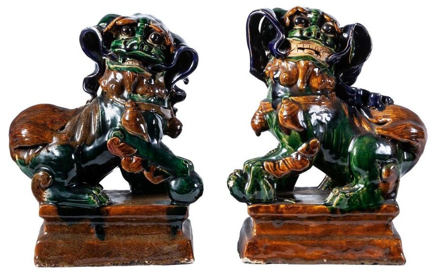 A pair of Tang-style sancai-glazed pottery Chinese guardian lions. Engraved...