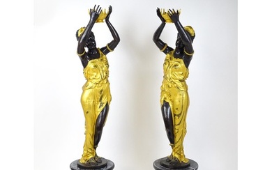 A pair of large cast bronze female blackamoor torcheres with...