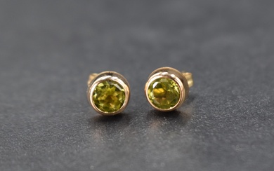 A pair of peridot stud earrings set in 9ct gold bezel settings, 0.5g