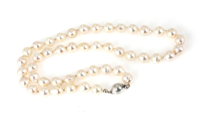 A pearl necklace set with numerous cultured pearls and a silver clasp....