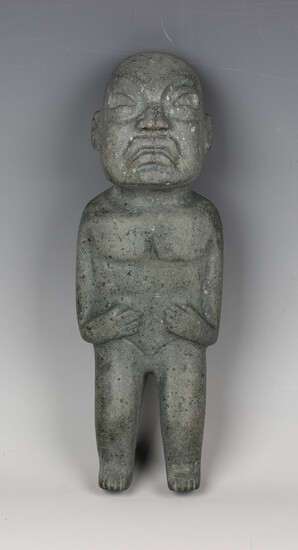 A pre-Columbian Olmec style carved green hardstone standing male figure, probably 900-450 BC, bearin