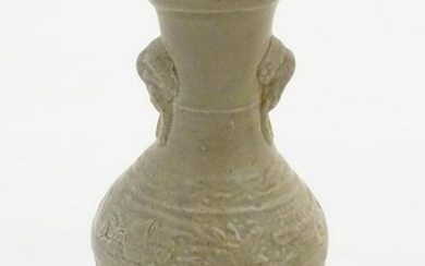 An Oriental earthenware vase with a flared base and