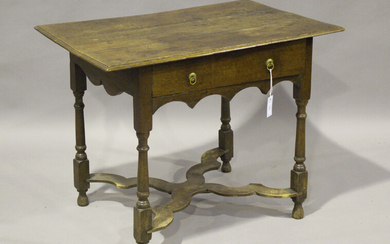 An early 18th century oak side table, fitted with a single drawer, on turned legs united by a shaped
