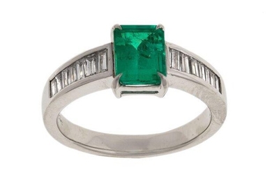 An emerald and diamond ring, claw set with a cut-cornered rectangular emerald to a tapering band, the shoulders channel set with baguette diamonds, ring size 1/12