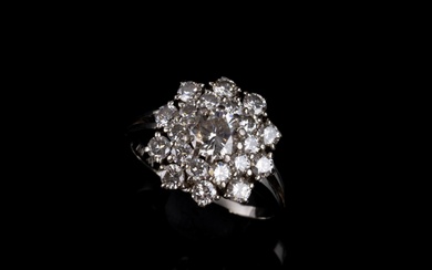 Bague en or blanc 18 carats (soit 750/1000e), ornée d'un diamant central dans un entourage...